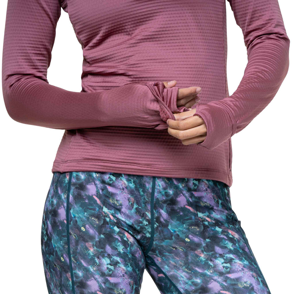 A model demonstrating the over-mitt on sleeve of the Ronhill Women's Tech Winter 1/2 Zip in the Dusty Tulip/Dark Navy colourway. (8747552211106)