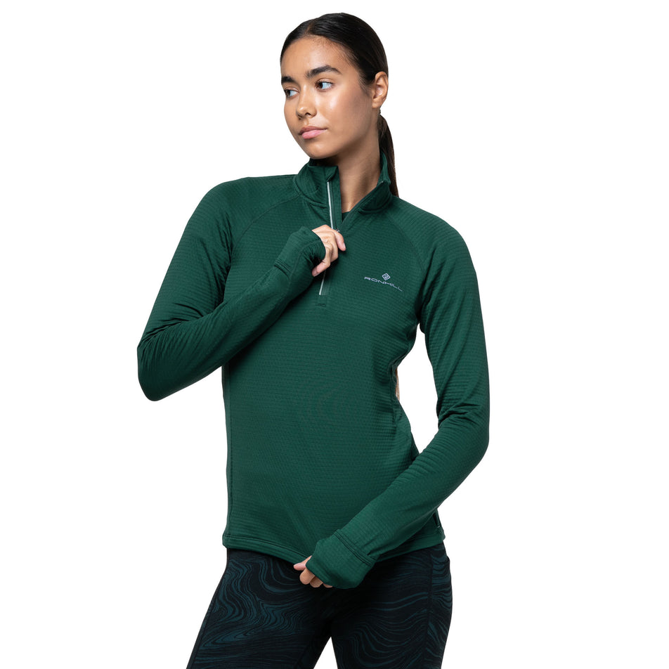Front view of a model wearing the Ronhill Women's Tech Winter 1/2 Zip in the Seaweed/Iris colourway. (8747564925090)