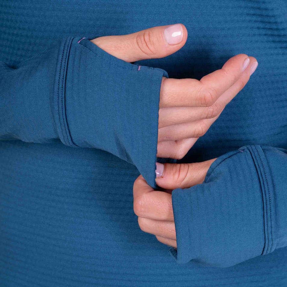 Close-up view of the thumb loops being used on the Ronhill Women's Tech Winter 1/2 Zip in the Legion Blue/Orchid colourway.