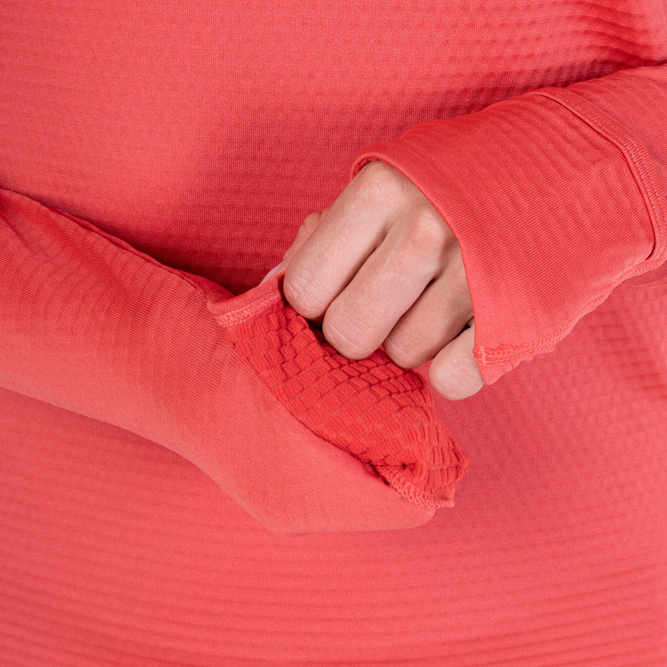 A model demonstrating the thumbloops and mitt on the Ronhill Women's Tech Winter 1/2 Zip in the Sumac/Blue Violet colourway.