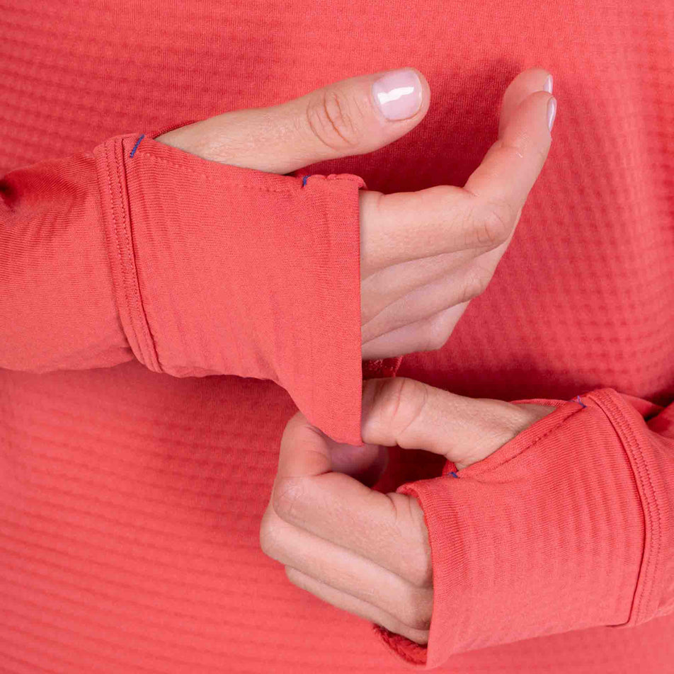 A model demonstrating the thumbloops on the Ronhill Women's Tech Winter 1/2 Zip in the Sumac/Blue Violet colourway.