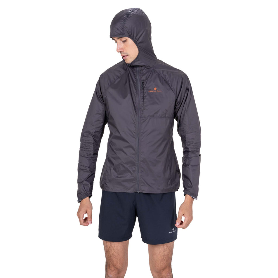 Front view of a model wearing the Ronhill Men's Tech All-Terrain Jacket in the Oxide/Ronhill Red colourway.