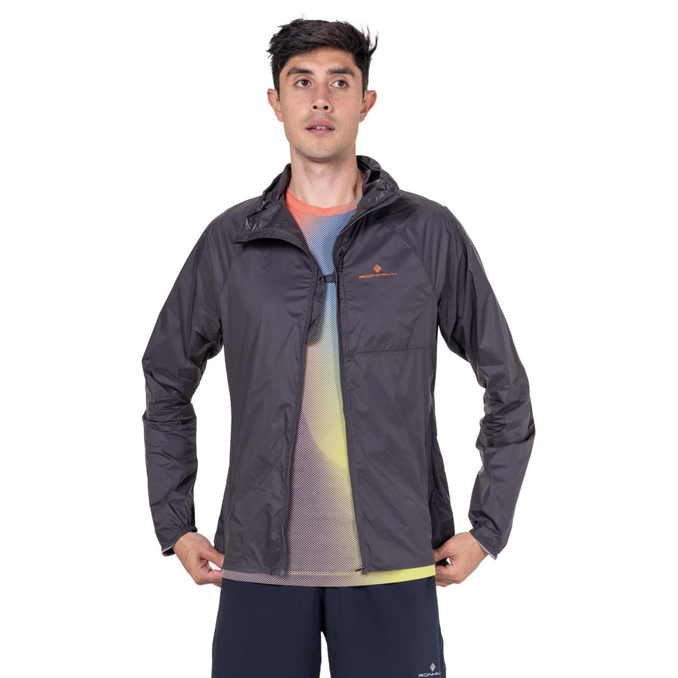 Front view of a model wearing the Ronhill Men's Tech All-Terrain Jacket in the Oxide/Ronhill Red colourway.