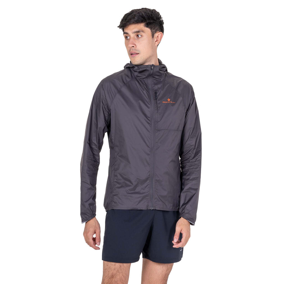 Front view of a model wearing the Ronhill Men's Tech All-Terrain Jacket in the Oxide/Ronhill Red colourway.