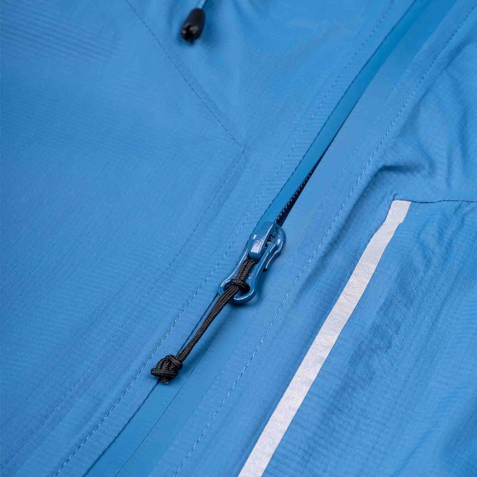 Close-up view of the front zip on the Ronhill Men's Tech Storm Jacket in the Glacier/Ronhill Red colourway.