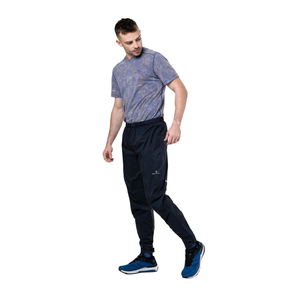 Front view of a model wearing the Ronhill Unisex Tech Storm Pant in the All Black colourway. (8748339593378)