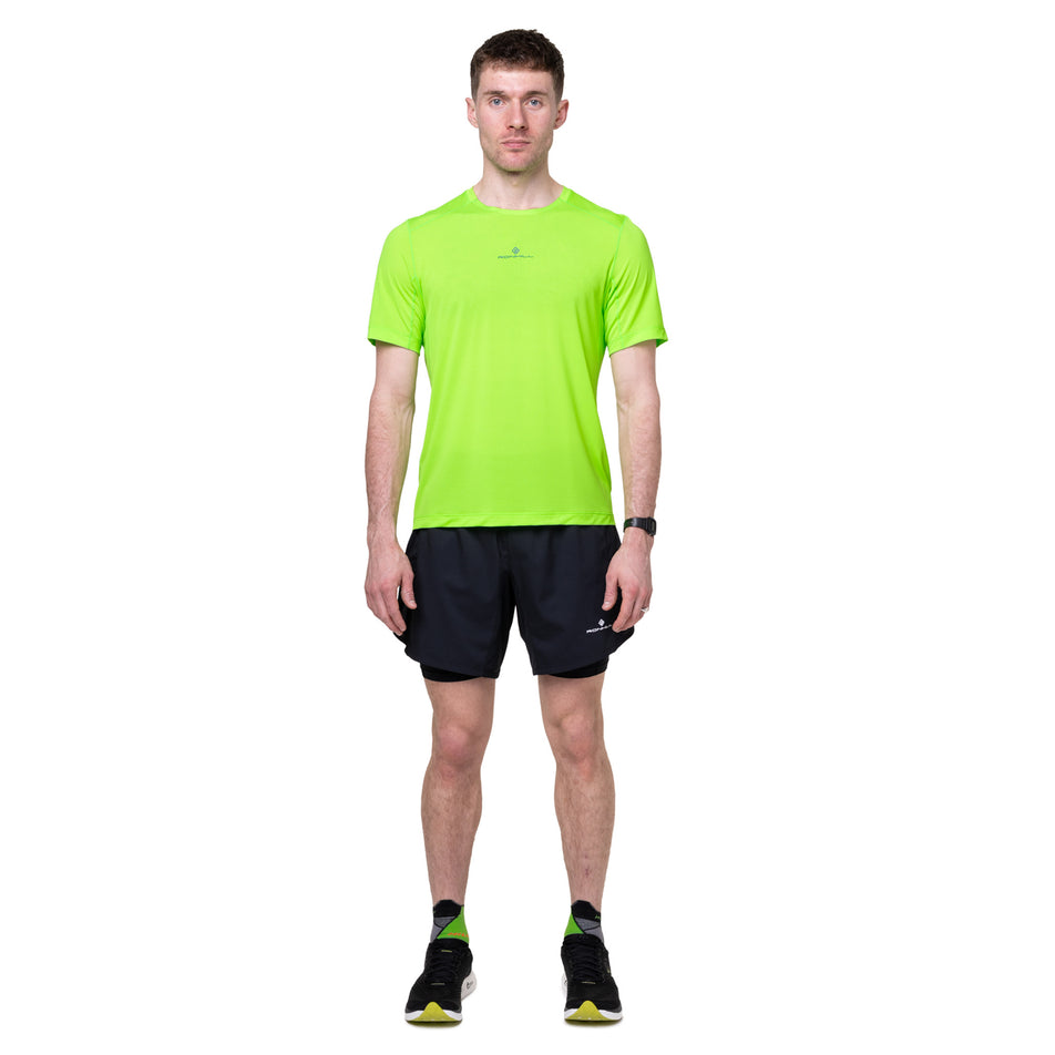 Front view of a model wearing the Ronhill Men's Tech S/S Tee in the Fluo Green/Dark Cobalt colourway.