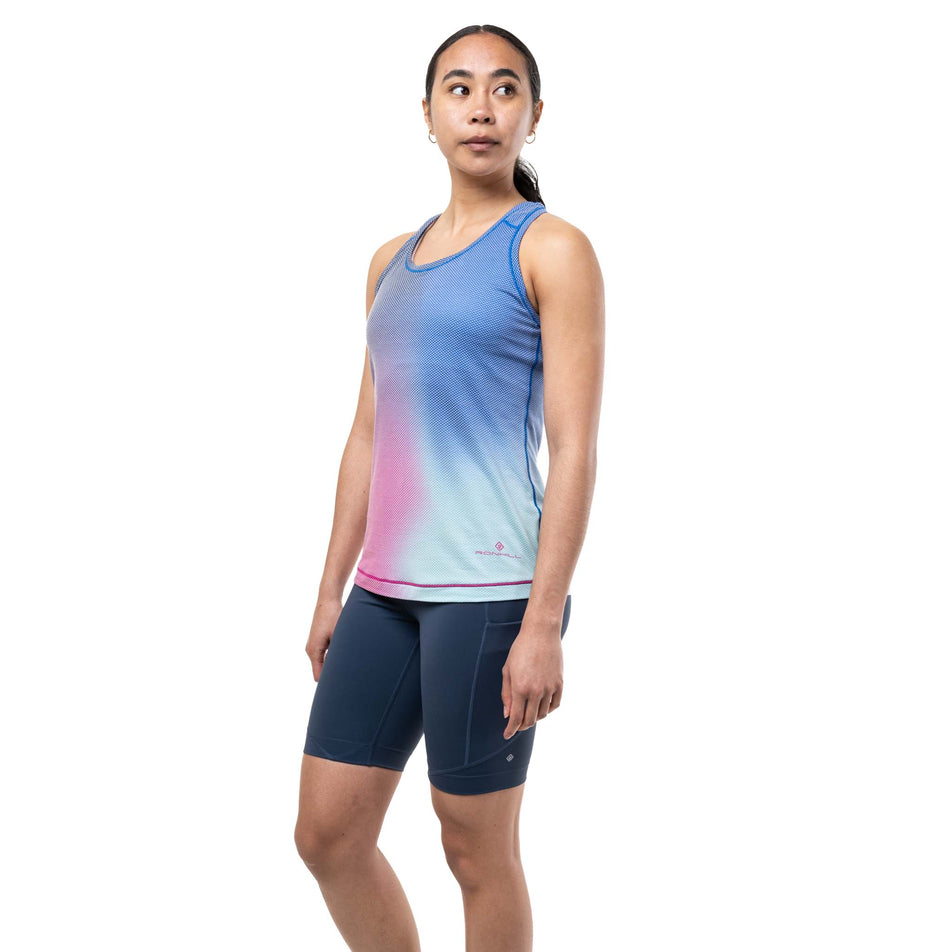 Front view of a model wearing the Ronhill Women's Tech Golden Hour Vest in the Exuberance Merge colourway.