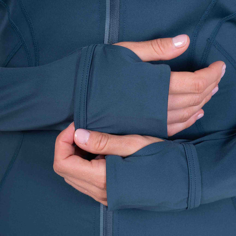 Close-up view of a model demonstrating the thumb loops on the Ronhill Women's Tech Contour Jacket in the Evening Haze colourway. 