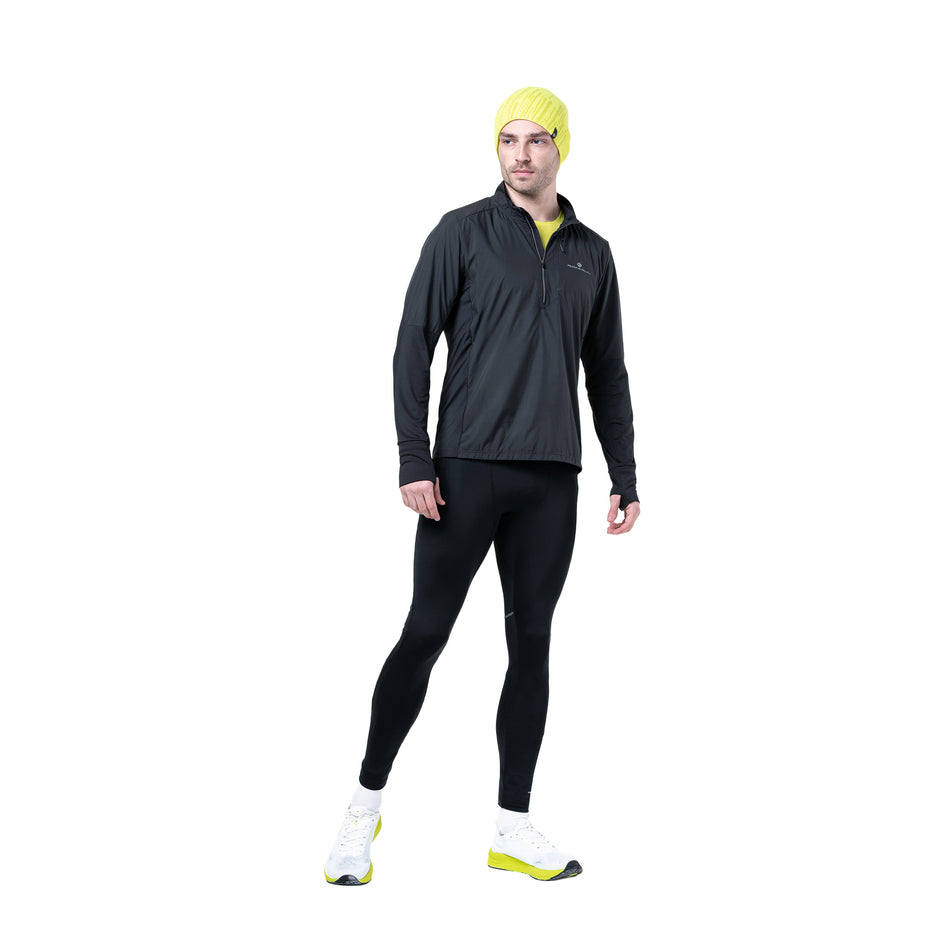 Front view of a model wearing the Ronhill Men's Tech Wind-Block 1/2 Zip in the All Black colourway. (8742870352034)