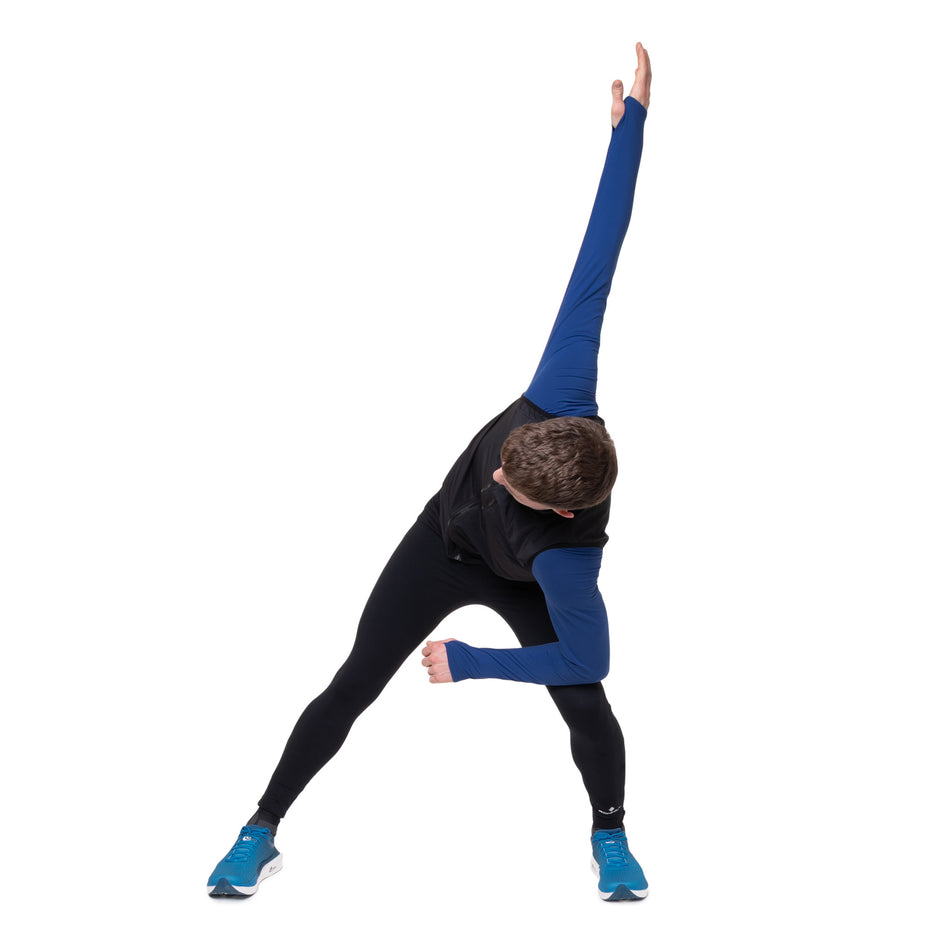 Angled view of a model wearing the Ronhill Men's Core Gilet in the Black/Bright White colourway.