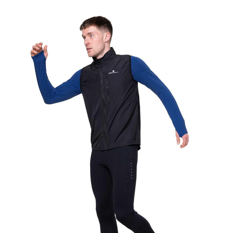 Angled view of a model wearing the Ronhill Men's Core Gilet in the Black/Bright White colourway.