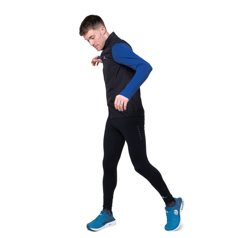 Angled view of a model wearing the Ronhill Men's Core Gilet in the Black/Bright White colourway.