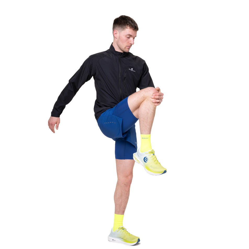 Angled view of a model wearing the Ronhill Men's Core Jacket in the Black/Bright White colourway.