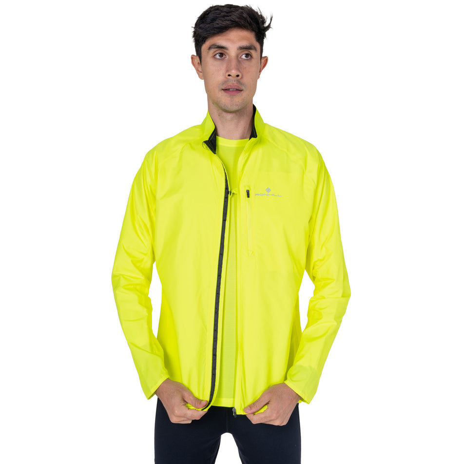 Front view of a model wearing the Ronhill Men's Core Jacket in the Fluo Zest colourway.