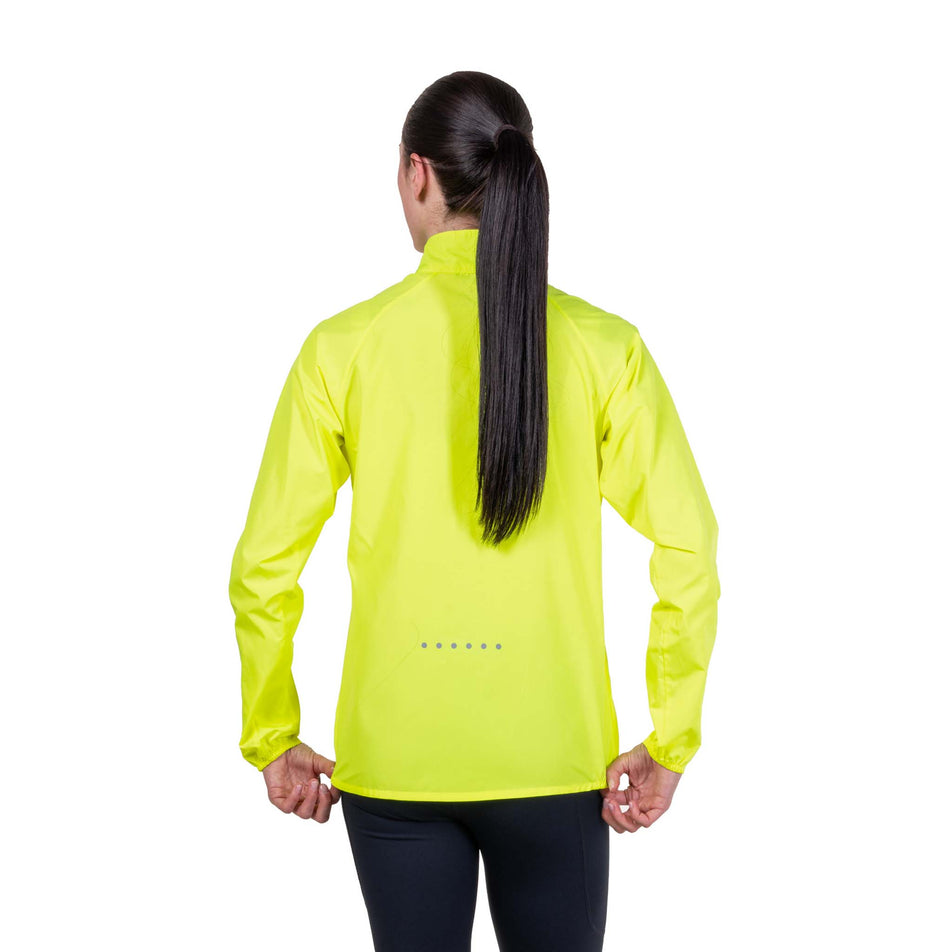 Back view of a model wearing the Ronhill Women's Core Jacket in the Fluo Zest colourway.