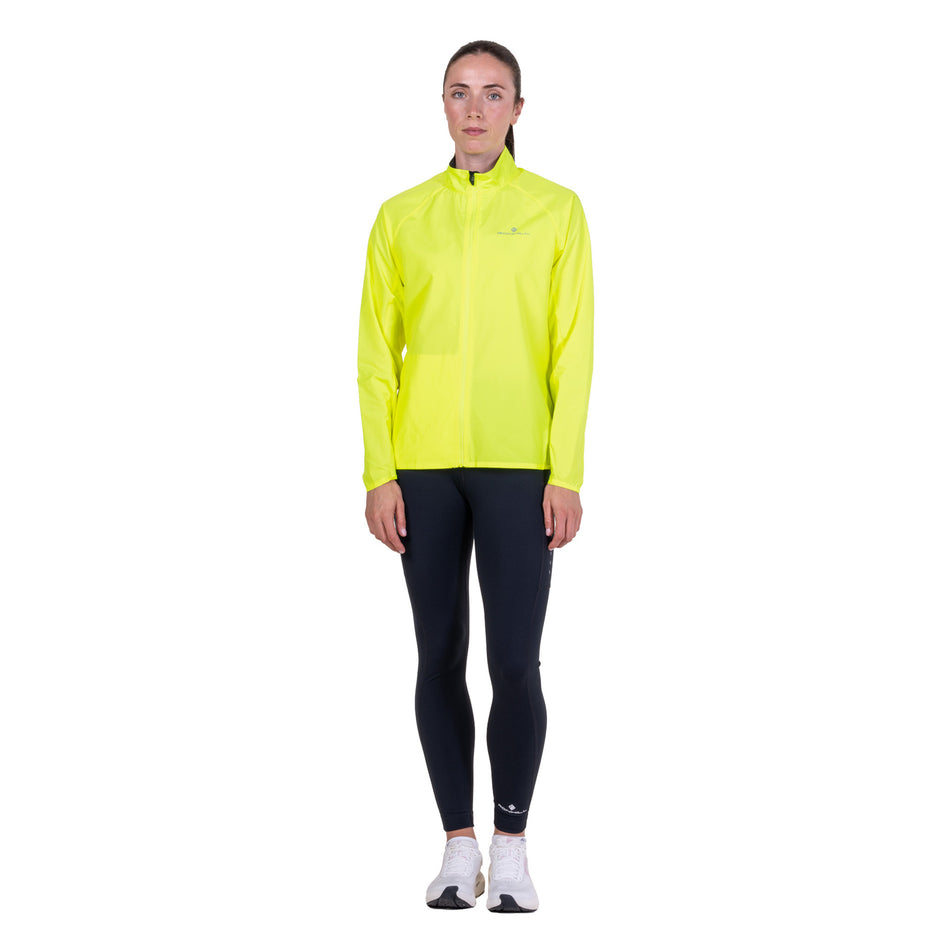 Front view of a model wearing the Ronhill Women's Core Jacket in the Fluo Zest colourway.