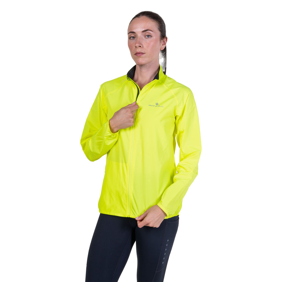 Front view of a model wearing the Ronhill Women's Core Jacket in the Fluo Zest colourway.