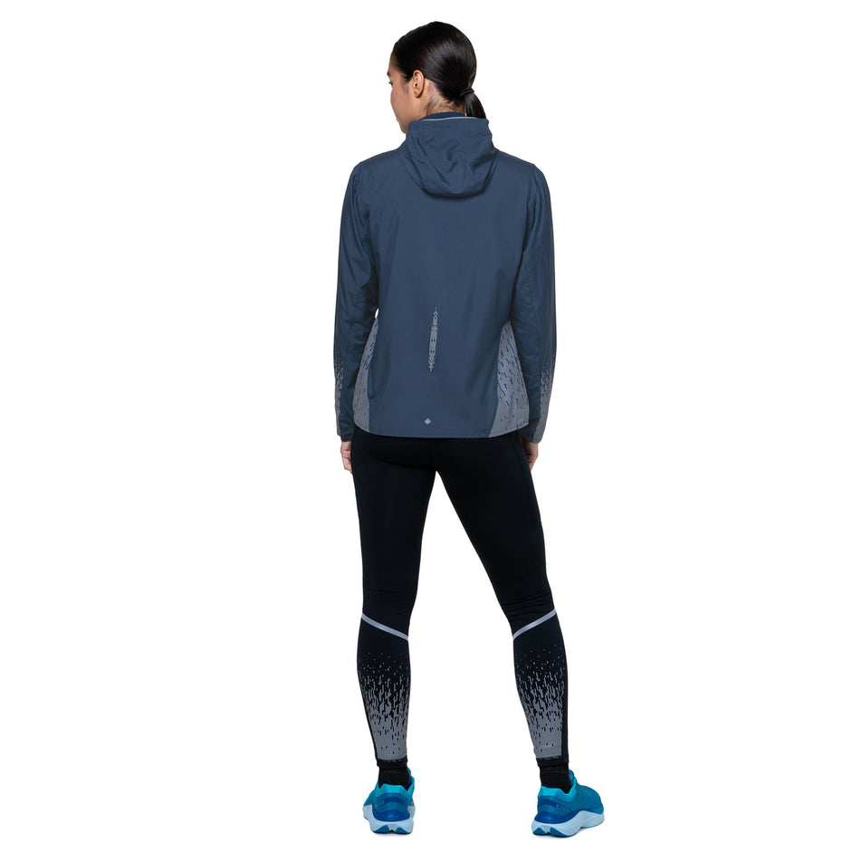 Back view of a model wearing the Ronhill Women's Tech Reflect Jacket in the Dark Navy/Reflect colourway. (8747149787298)