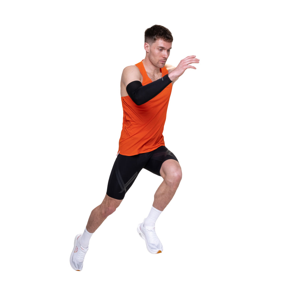 Angled view of a model wearing the Ronhill Men's Tech Race Half Tight in the All Black colourway.