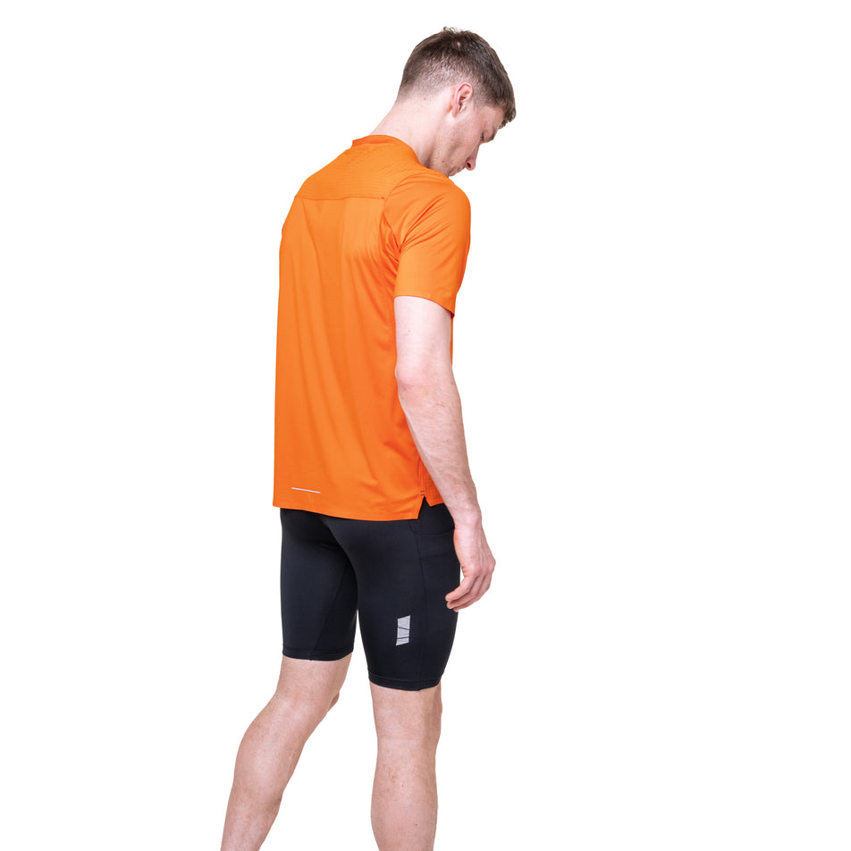 Angled view of a model wearing the Ronhill Men's Tech All-Terrain S/S Tee in the Ronhill Red colourway.