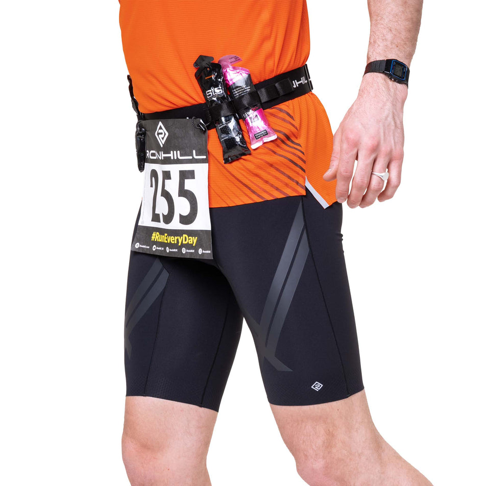 Angled view of a model wearing the Ronhill Race Number Belt in the All Black colourway.