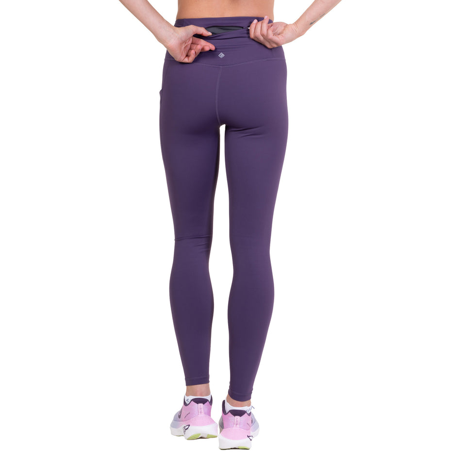 Back view of a model wearing the Ronhill Women's Tech Contour Tight in the Noir Iris colourway.