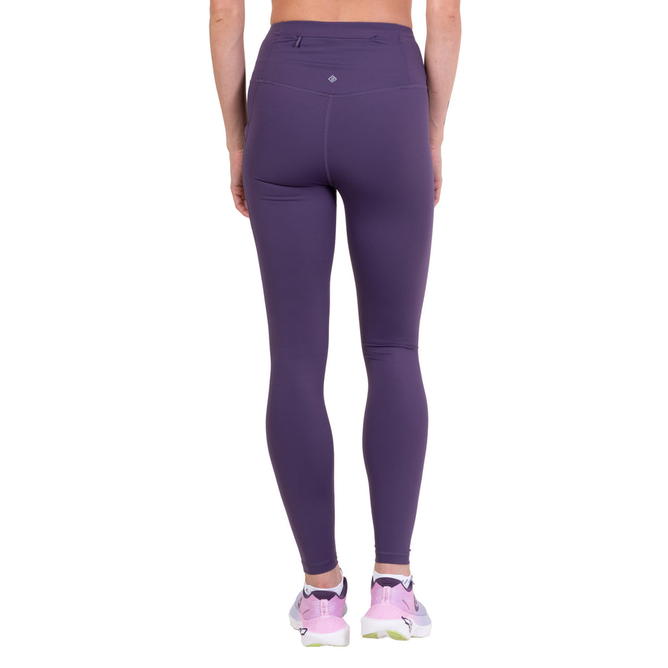 Back view of a model wearing the Ronhill Women's Tech Contour Tight in the Noir Iris colourway.