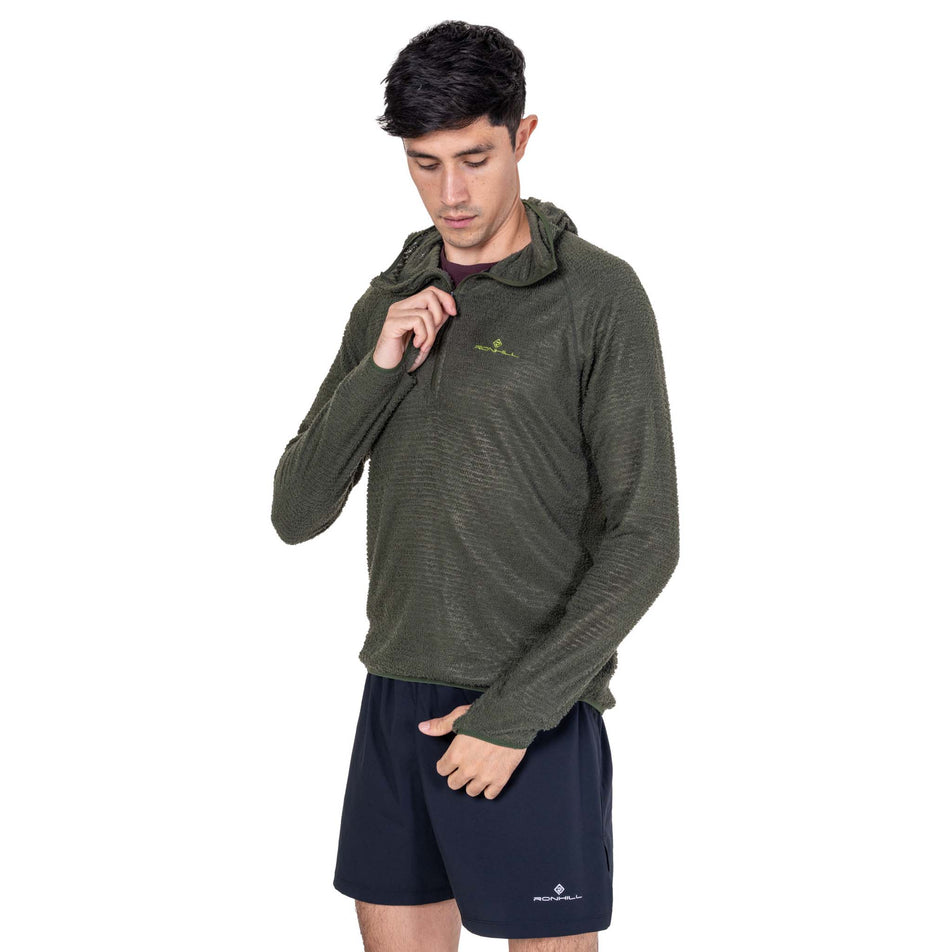 Front view of a model wearing the Ronhill Men's Tech Winter Primaloft Hoodie in the Kelp/Zest colourway.