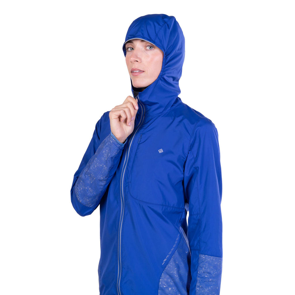 Front view of a model wearing the Ronhill Women's Tech Reflect Jacket in the Blue Violet/Reflect colourway.