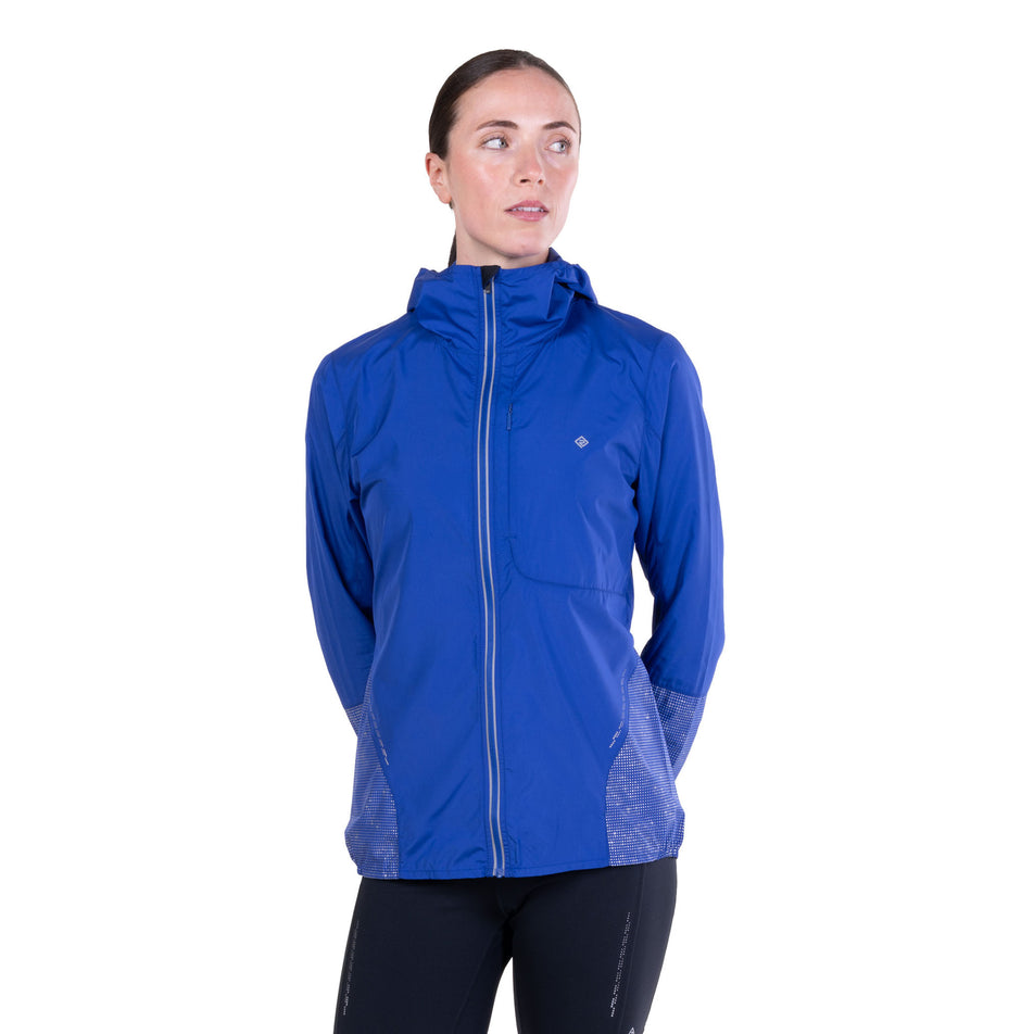 Front view of a model wearing the Ronhill Women's Tech Reflect Jacket in the Blue Violet/Reflect colourway.