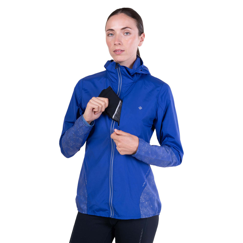 A model demonstrating the chest pocket on the Ronhill Women's Tech Reflect Jacket in the Blue Violet/Reflect colourway.