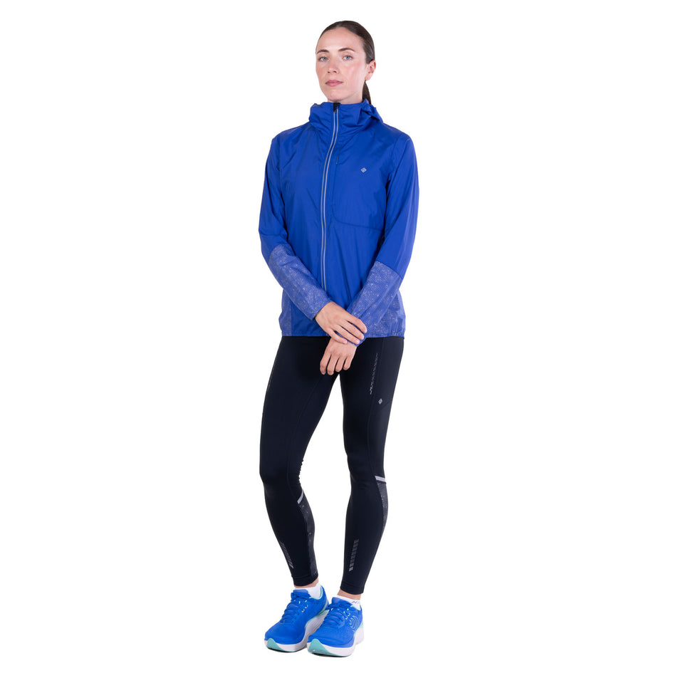 Front view of a model wearing the Ronhill Women's Tech Reflect Jacket in the Blue Violet/Reflect colourway.