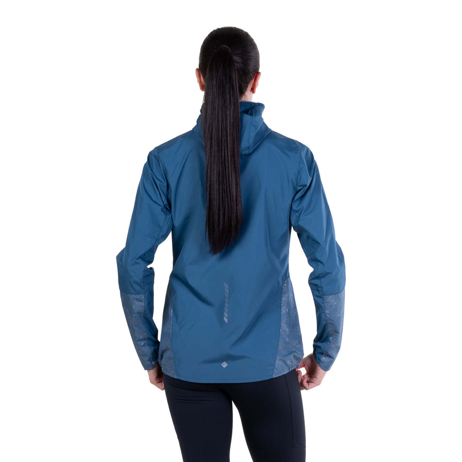 Back view of a model wearing the Ronhill Women's Tech Reflect Jacket in the Legion Blue/Reflect colourway.