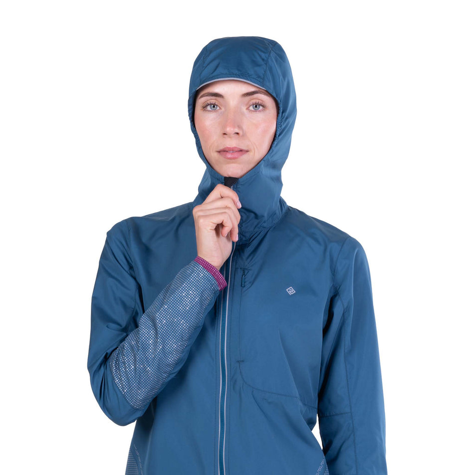 Front view of a model wearing the Ronhill Women's Tech Reflect Jacket in the Legion Blue/Reflect colourway.