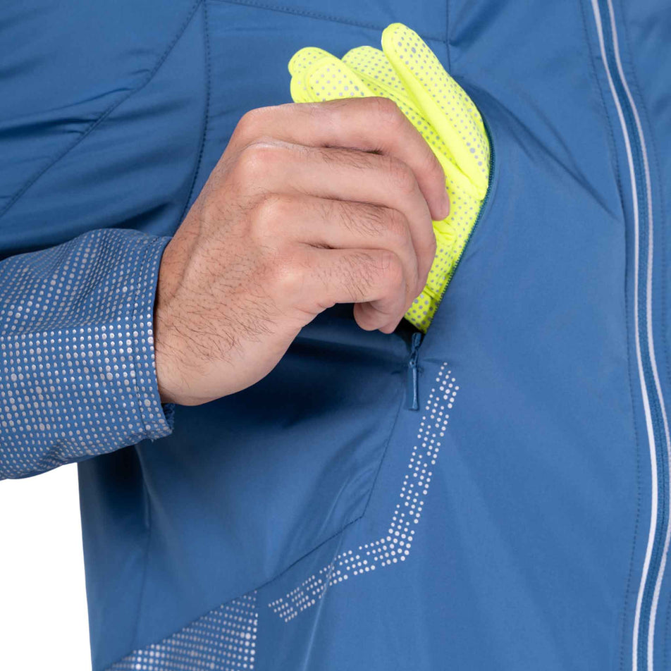 Close-up view of the zippered pocket on the Ronhill Men's Tech Reflect Jacket in the Glacier/Reflect colourway.