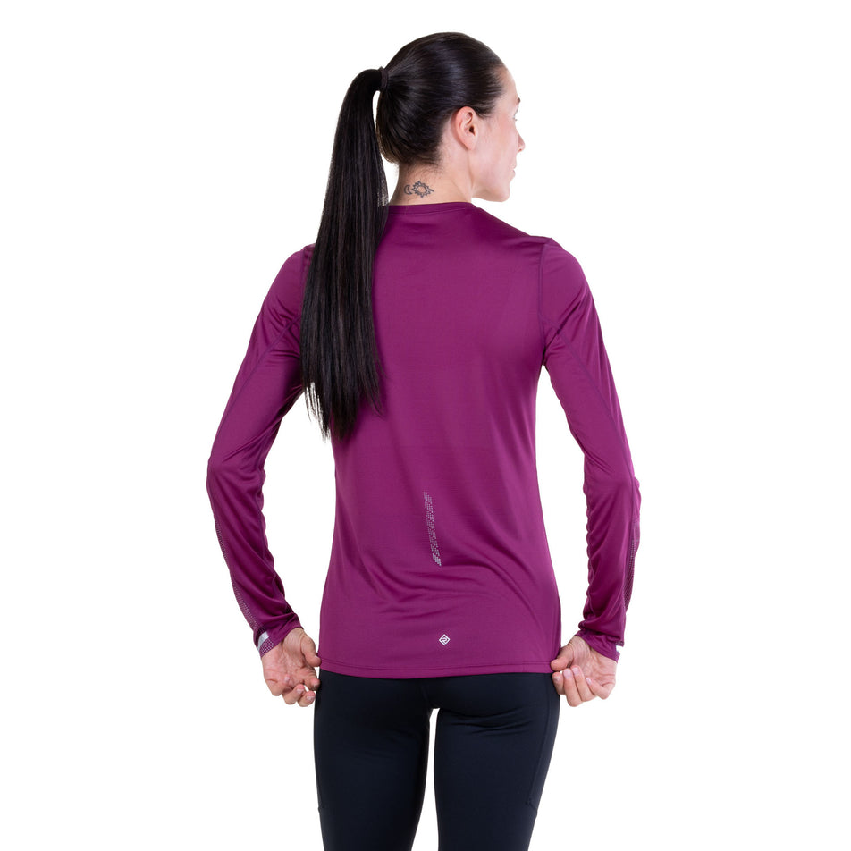 Back view of a model wearing the Ronhill Women's Tech Reflect L/S Tee in the Blackcurrant/Reflect colourway.