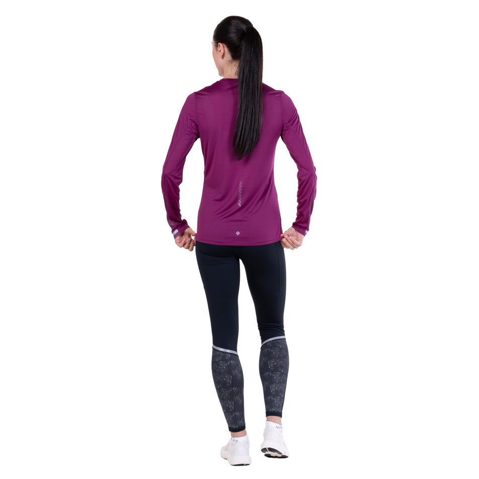 Back view of a model wearing the Ronhill Women's Tech Reflect L/S Tee in the Blackcurrant/Reflect colourway.