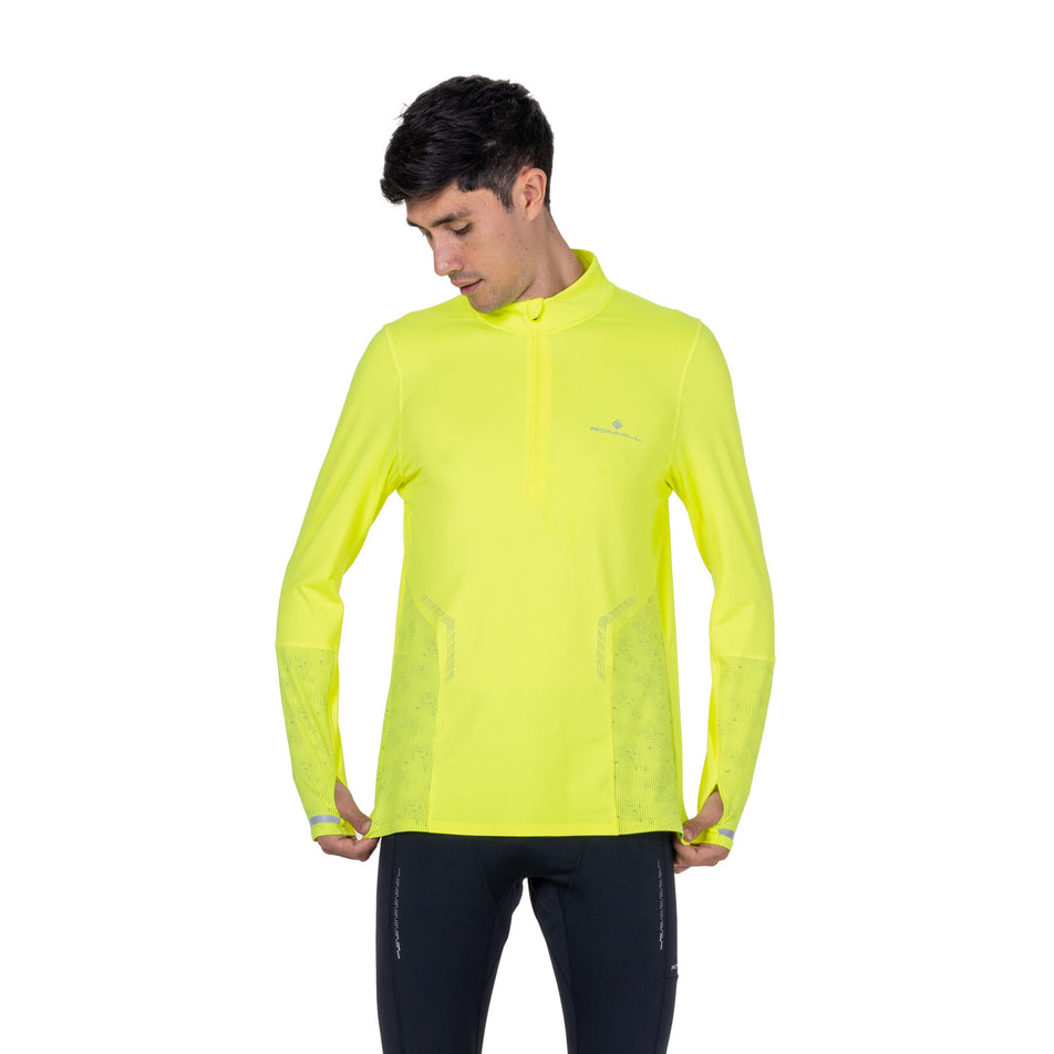Front view of a model wearing the Ronhill Men's Tech Reflect 1/2 Zip in the Fluo Zest/Reflect colourway.