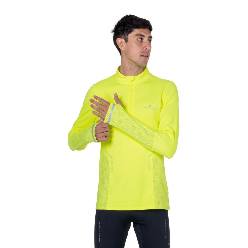 Front view of a model wearing the Ronhill Men's Tech Reflect 1/2 Zip in the Fluo Zest/Reflect colourway.