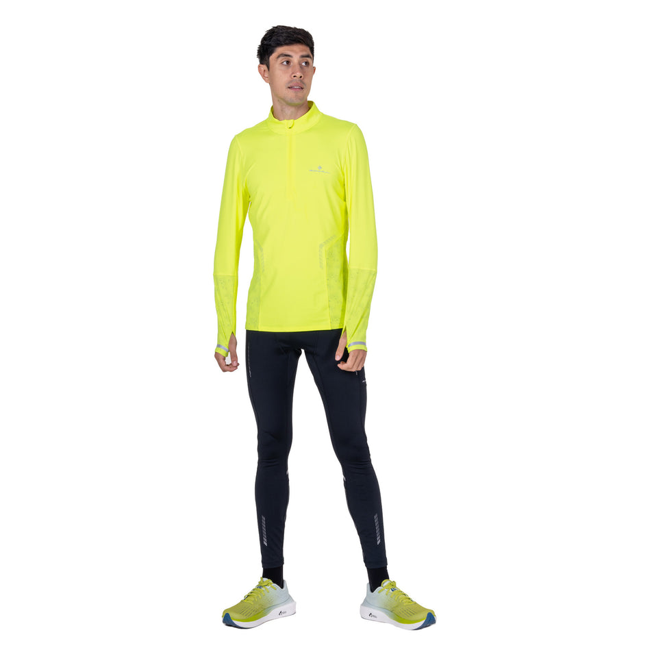 Front view of a model wearing the Ronhill Men's Tech Reflect 1/2 Zip in the Fluo Zest/Reflect colourway.