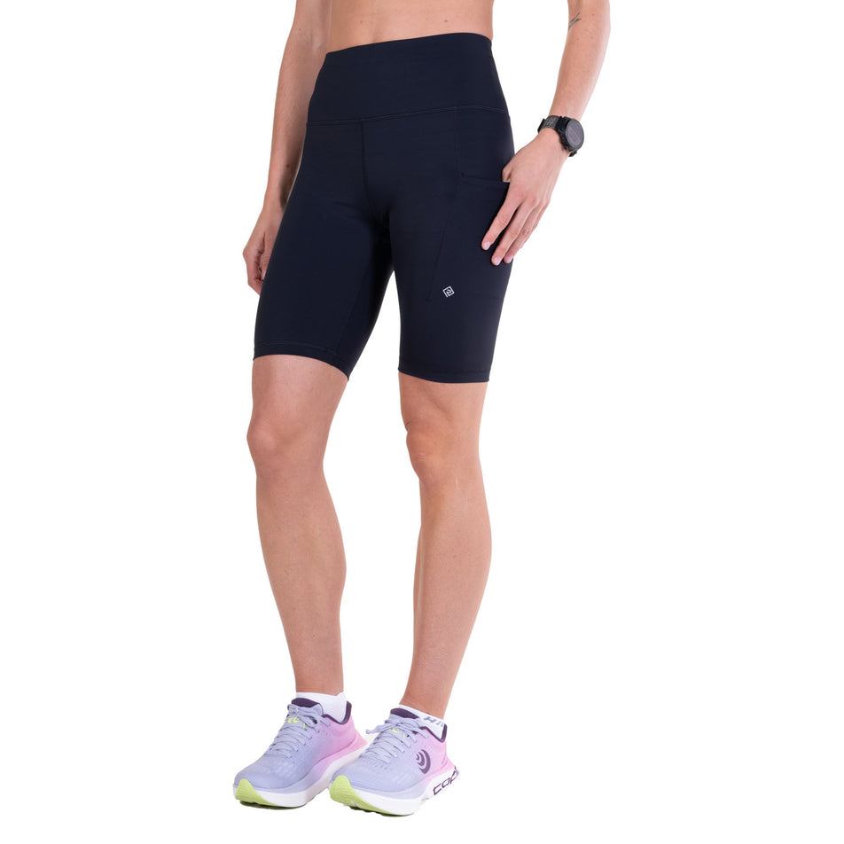 Angled view of a model wearing the Ronhill Women's Tech Contour Stretch Short in the All Black colourway.