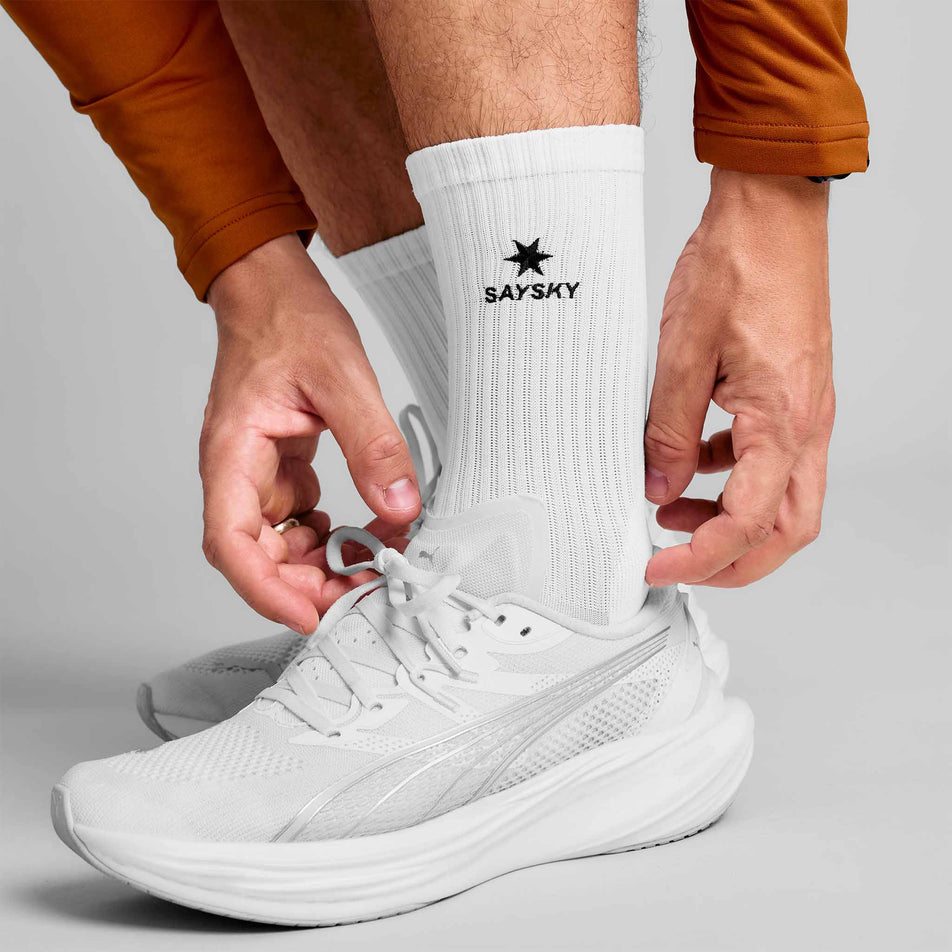 A model wearing a pair of SAYSKY Unisex Pace High Socks in the White colourway.