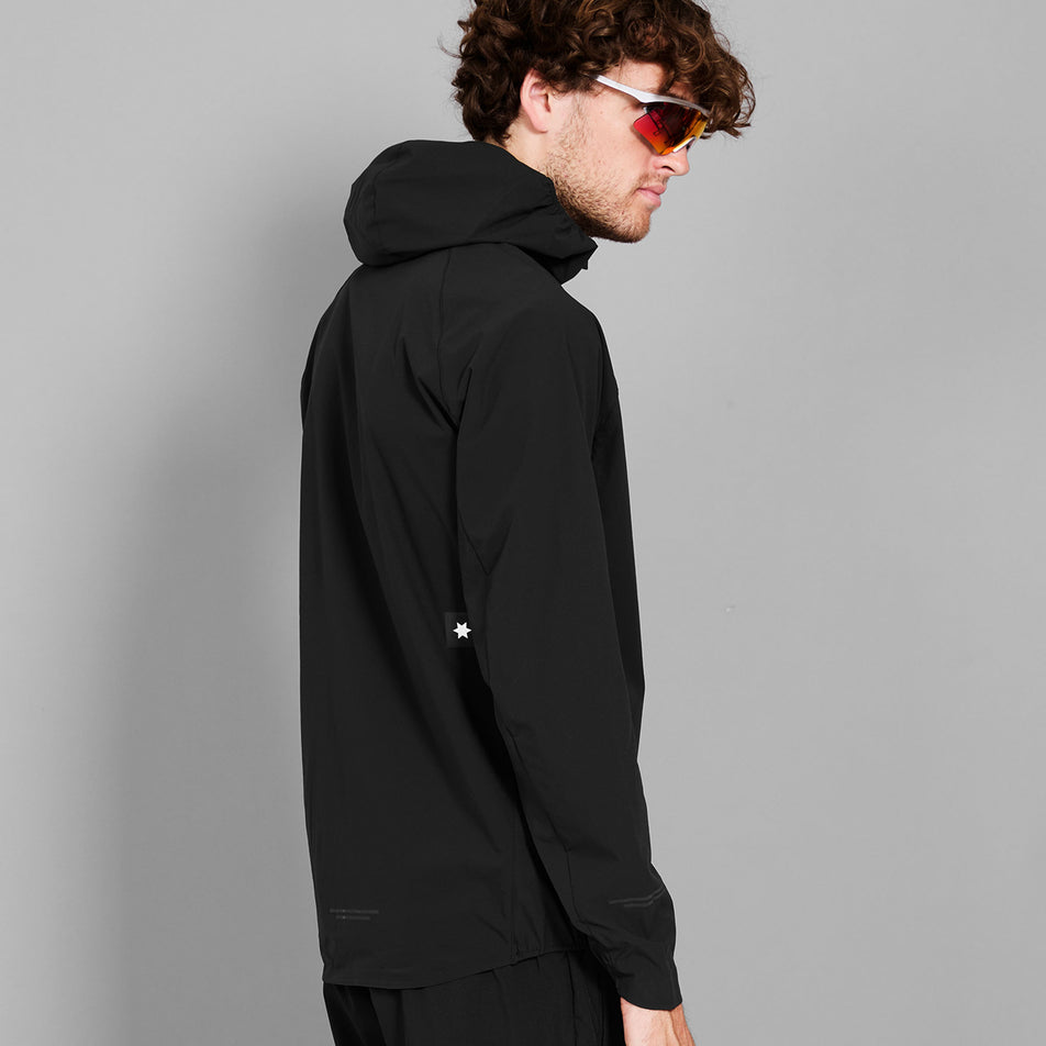Angled view of a model wearing the SAYSKY Men's Clean Pace Flex Hooded Jacket in the Black-26 colourway.