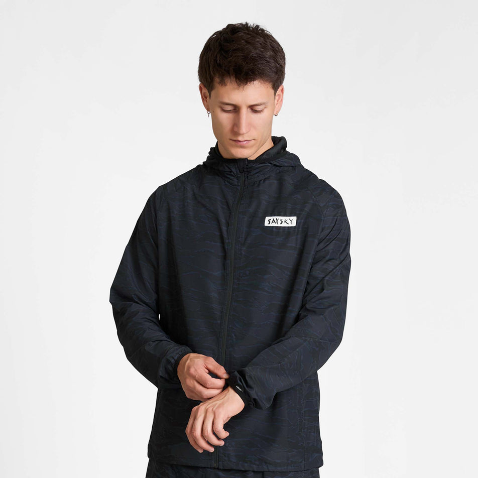 Front view of a model wearing the SAYSKY Men's Tiger Pace Jacket in the Black Camo colourway.