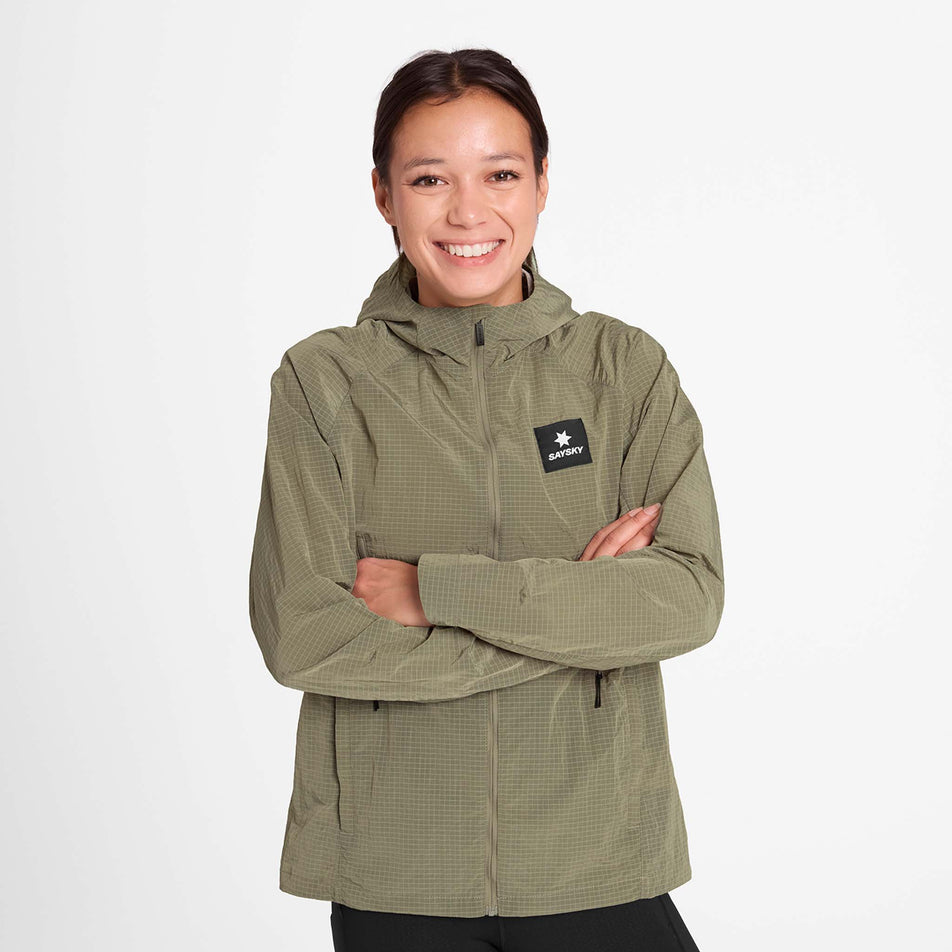 Front view of a model wearing the SAYSKY Women's Clean Pace Shield Jacket in the Beige colourway.