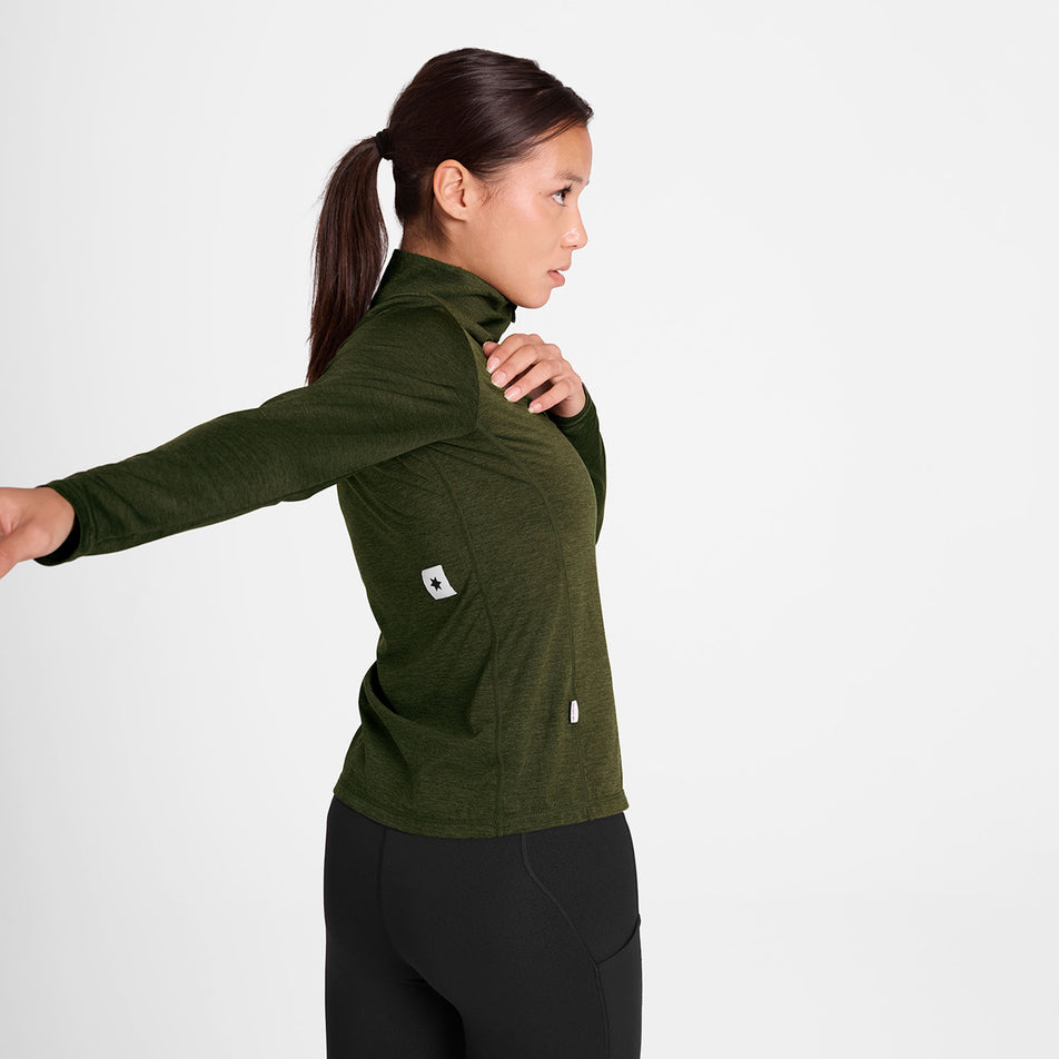 Angled view of a model wearing the SAYSKY Women's Pace 1/2 Zip Long Sleeve in the Green colourway.