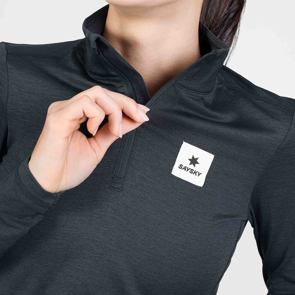 Close-up view of the chest zip on the SAYSKY Women's Tiger Pace Half Zip Long Sleeve in the Black colourway.