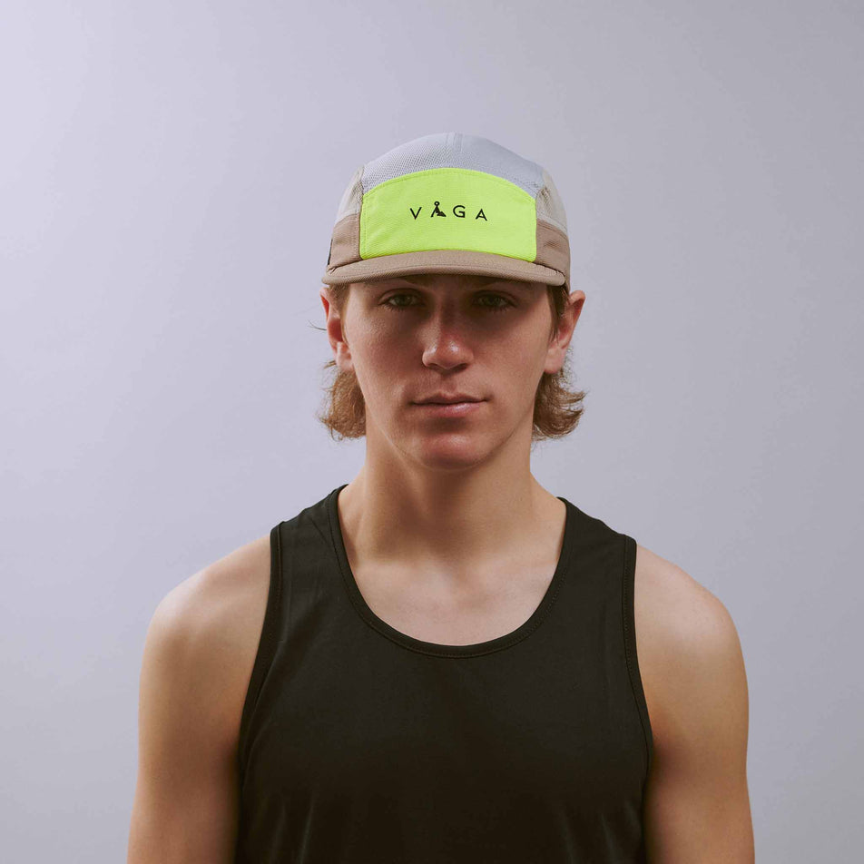 Front view of a model wearing the VÅGA Unisex Club Cap in the Taupe/Neon Yellow/Light Grey colourway.