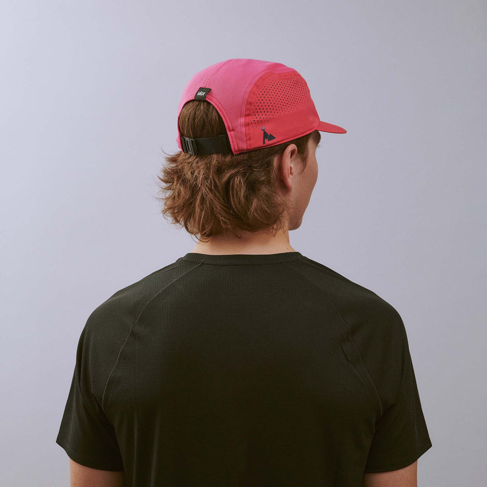 Back view of  a model wearing the VÅGA Unisex Feather Racing Cap in the Pink colourway. 